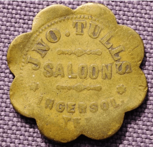 Brass token from Jno. Tulls Saloon in Ingersoll, featuring a scalloped edge and embossed text, highlighting a historical establishment.
