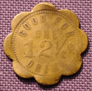 Token labeled "Good for one 12½ drink," with a scalloped edge, showcasing vintage currency used for beverages, relevant to historical pricing.