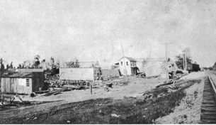 Ruined buildings and debris scattered across a landscape, illustrating the aftermath of a disaster in a rural area, likely from the early 20th century.